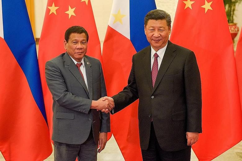 Remains of a victim of the Marawi siege at a mass burial in Marawi yesterday. Philippine President Rodrigo Duterte with his Chinese counterpart Xi Jinping in Beijing recently. Mr Duterte's tax reforms aim to fund his S$215 billion infrastructure prog