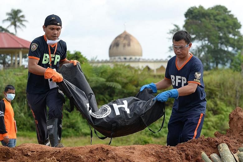 Remains of a victim of the Marawi siege at a mass burial in Marawi yesterday. Philippine President Rodrigo Duterte with his Chinese counterpart Xi Jinping in Beijing recently. Mr Duterte's tax reforms aim to fund his S$215 billion infrastructure prog