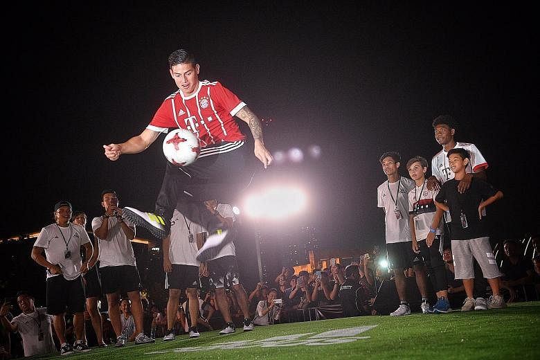 Bayern's new man James Rodriguez displaying his skills in front of fans, as team-mate David Alaba (right) looks on at Clifford Square during the adidas Football Freestyle Battle last night.
