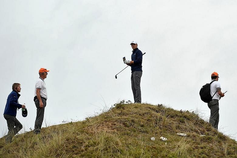 American Spieth studying the terrain on where to take the drop after landing in the rough off the 13th tee in the final round. His decision to take the third and final option paid off and he gave up only one shot.
