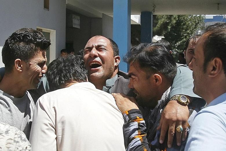 Relatives of the victims of a suicide bomb blast outside a hospital in Kabul, Afghanistan, yesterday. A Taleban suicide attacker set off a car bomb in the western part of Kabul yesterday, killing up to 35 people and wounding more than 40. At least 35