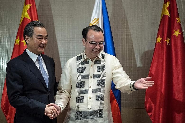 Chinese Foreign Minister Wang Yi (far left) meeting his Philippine counterpart Alan Peter Cayetano in Manila yesterday. Mr Wang said joint development of natural resources in disputed waters "is full of political wisdom".