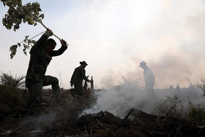 Indonesian military personnel trying to extinguish a fire in the swamp land in Meulaboh in West Aceh, Indonesia, yesterday. Hundreds of hectares of swamp land in West Aceh are on fire, due to the long dry season and land clearing activity conducted t