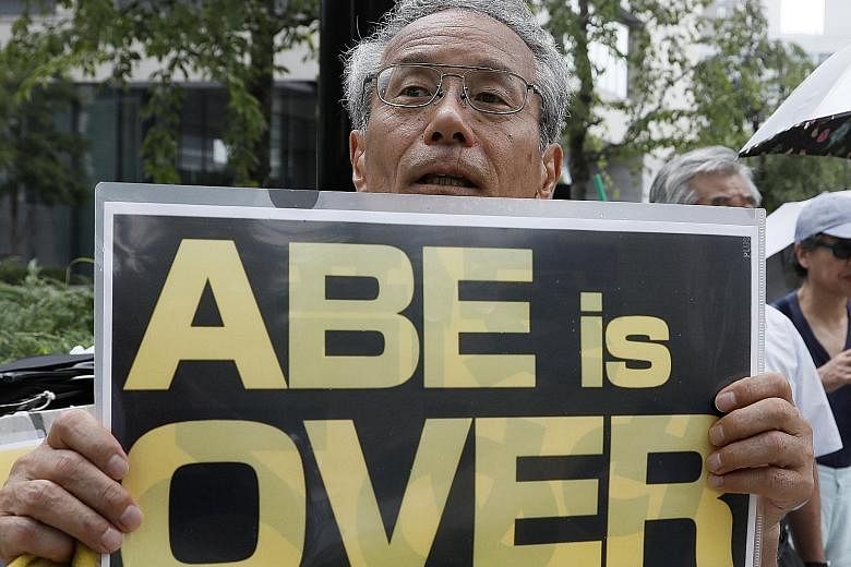 A demonstrator outside Parliament in Tokyo yesterday as Prime Minister Shinzo Abe tries to defend himself against accusations of cronyism during a special parliamentary session.