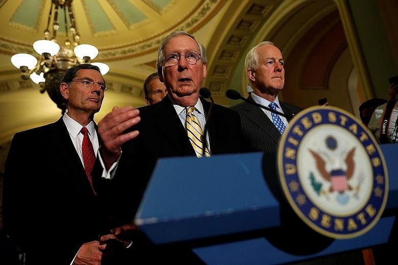 Senate Majority Leader Mitch McConnell, flanked by Texas Senator John Cornyn (right) and Wyoming Senator John Barrasso, speaking to reporters on Capitol Hill in Washington on Tuesday.
