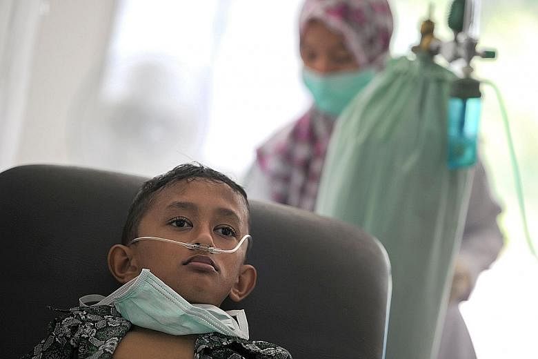 An Acehnese boy undergoing treatment for lung infection from thick smoke due to peat forest fires in Meulaboh last Sunday. Indonesia's disaster mitigation agency has warned of an escalating threat of forest fires with the dry season expected to peak 