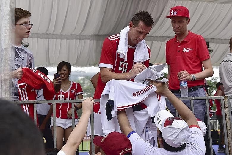 Former Bayern Munich striker Miroslav Klose, the all-time World Cup top scorer, signing autographs for fans during a Bayern Munich Fan Club tournament at the Padang yesterday. The event saw former Bayern players Giovane Elber, Hasan Salihamidzic and 
