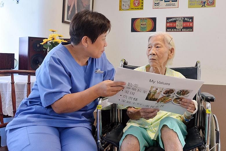 Madam Mary Ho, who has mild dementia, taking part in an activity to stimulate the brain with therapist Anna Lee at the St Andrew's Community Hospital. Madam Ho also attends Life story sessions at the hospital, where dementia patients share their stor