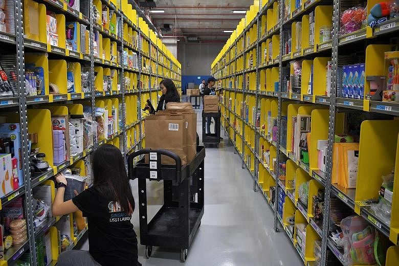Staff packing orders yesterday at Amazon's Prime Now Fulfilment Centre in Singapore, which is now its largest in the world. Through the Prime Now app, customers can get products delivered to them in two hours.