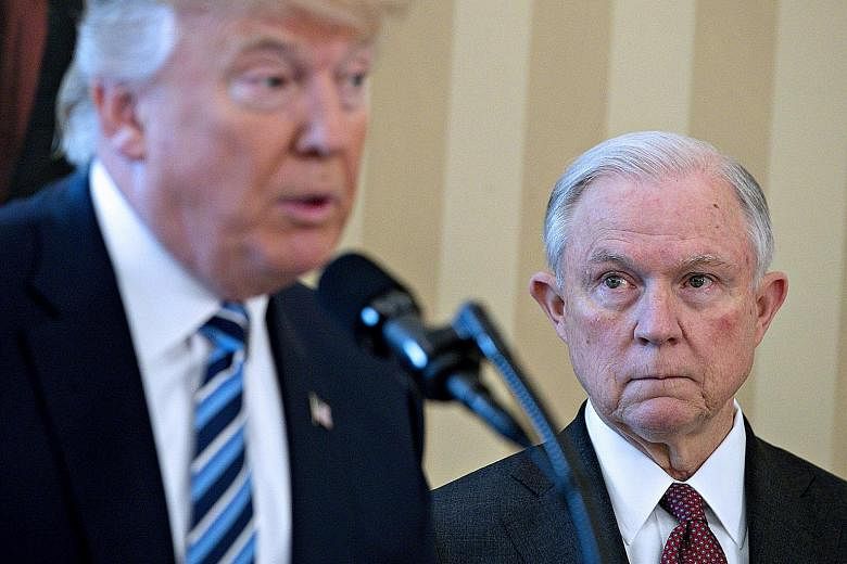 Attorney-General Jeff Sessions listening to President Donald Trump at the former's swearing-in ceremony in February. Mr Trump's criticism of the Attorney-General is seen as a bullying tactic to get Mr Sessions to quit, in order to make way for a repl