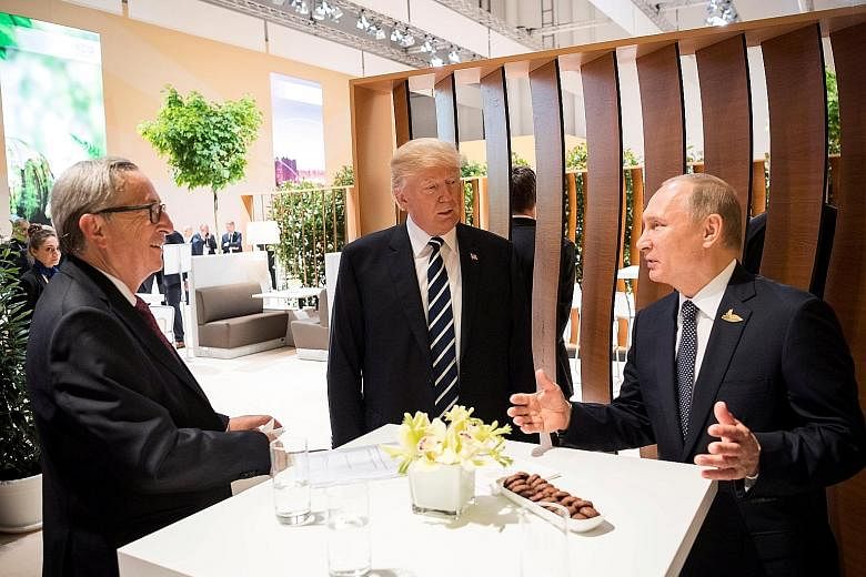 From far left: European Commission president Jean-Claude Juncker, US President Donald Trump and Russian President Vladimir Putin in Hamburg, Germany, earlier this month. Mr Juncker said the new US sanctions could have "unintended unilateral effects t