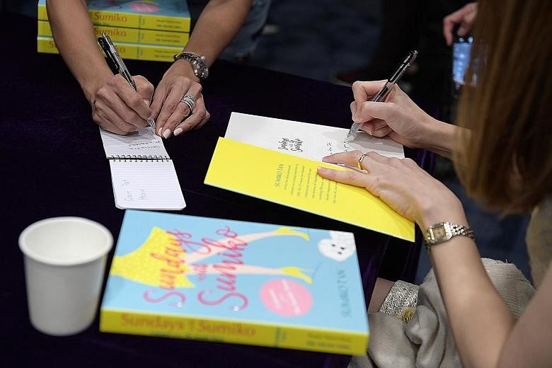 The Straits Times executive editor Sumiko Tan (left) says she was nervous before her askST@NLB session yesterday, but says readers of her column were "very warm". Ms Tan signs copies of her book Sundays With Sumiko (above).