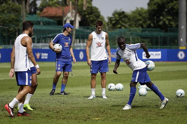 Chelsea midfielder Cesc Fabregas (far left) and Alvaro Morata look on as team-mate N'Golo Kante attempts to block a pass during a training session at the Singapore American School.
