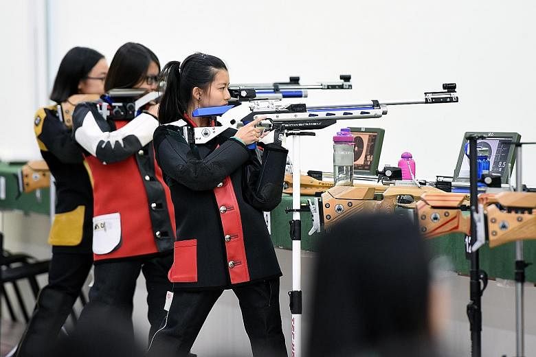 Above: Northbrooks Secondary's Gai Tianrui, 14, is the C Div boys' 10m air rifle winner. Left: Callie Siah (right) in action during the C Div girls' 10m air rifle final. She came from behind to win with 244.6 points.