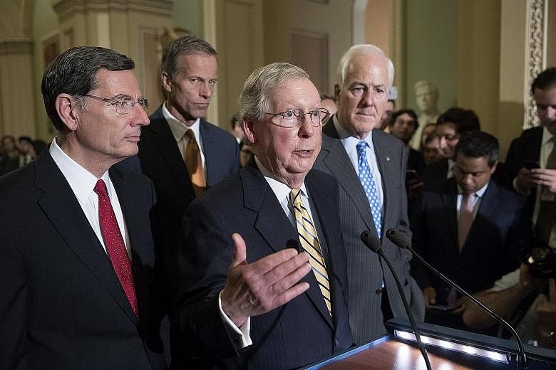Senate Majority Leader Republican Mitch McConnell (centre) on Tuesday after the Senate voted to proceed on Mr Donald Trump's effort to repeal and replace Obamacare. The attempt failed yesterday.