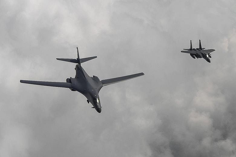 A handout photo made available by the South Korean Air Force shows a US B1-B bomber (left) escorted by a South Korean F-15K fighter during the mission over the Korean peninsula yesterday.