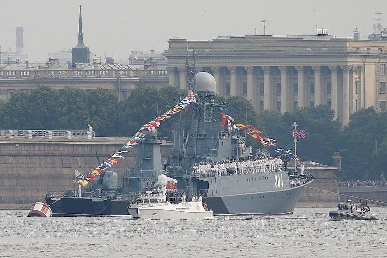 Russian President Vladimir Putin overseeing the Navy Day parade on board his white presidential cutter along the Neva River near St Petersburg yesterday.