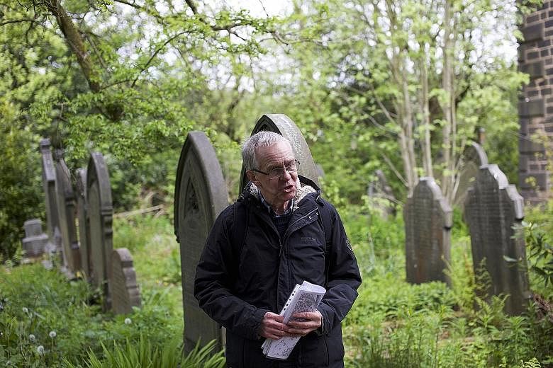 A volunteer leading a tour of a graveyard in the town of Todmorden in West Yorkshire, Britain. The tours are part of a community-generated festival, called Pushing Up Daisies, that aims to start conversations about death, dying and bereavement. The f
