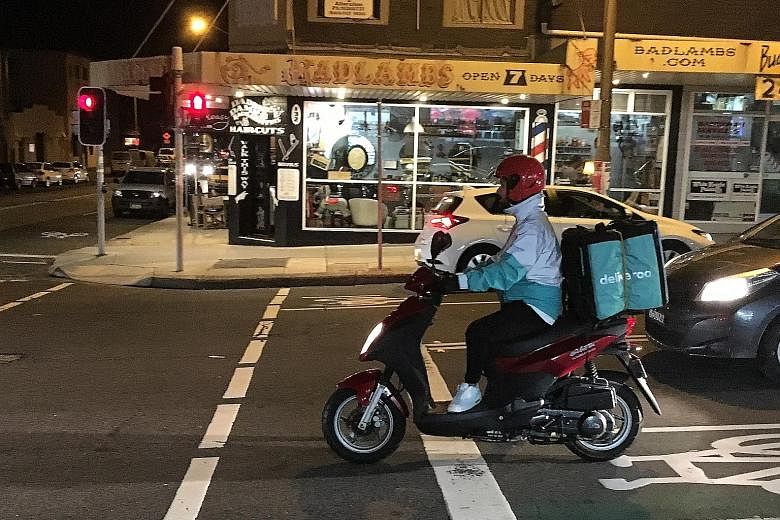 A Deliveroo rider making a delivery in Sydney. The market is dominated by UberEats, Deliveroo, Foodora and Menulog.