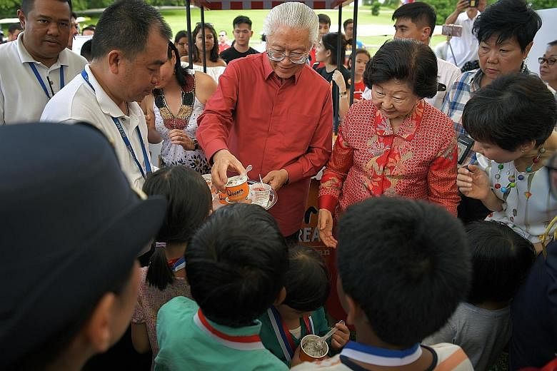 Visitors enjoying the greenery at the Istana during the open house yesterday. Left: President Tony Tan Keng Yam and his wife, Mrs Mary Tan, distributing Istana Harvest, a sorbet in celebration of Singapore's 52nd birthday, to children. Above: People 