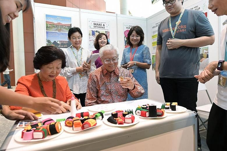 President Tony Tan Keng Yam and his wife Mary rolling and appreciating decorative "sushi" at the Institute of Mental Health booth at Singapore Press Holdings' (SPH) Chinese Media Group charity event in support of the President's Challenge 2017. SPH h