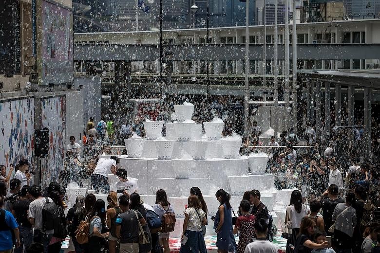 Guests and passers-by are thrilled at the sight of soap bubbles rising in the air during the showcase of an art installation outside Harbour City in Hong Kong yesterday. The art installation, titled Bubble Up, is designed by Japanese artist Shinji Oh