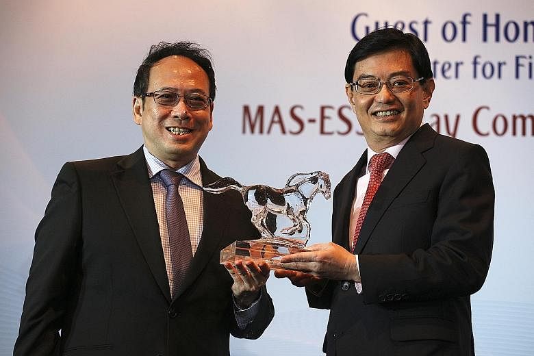 Finance Minister Heng Swee Keat receiving a token from Economic Society of Singapore president Euston Quah to signify his acceptance of the Honorary Fellow post yesterday during its annual dinner at Mandarin Orchard Singapore. Only five other people 