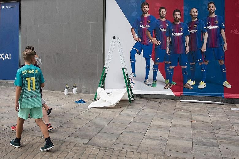 A new poster being put up outside Barcelona's Camp Nou stadium. The previous poster featured Barca forward Neymar, who is expected to land in Paris today ahead of his impending move to PSG despite a hitch. Spain's LaLiga turned down the Brazilian's l