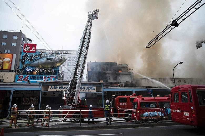 Japanese firefighters trying to extinguish the fire at Tokyo's landmark Tsukiji fish market yesterday. The blaze was in Tsukiji's "outer" market, and spread to five buildings covering some 300 sq m later in the evening. There were no immediate report