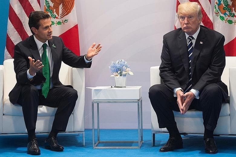 Mexican President Enrique Pena Nieto and his US counterpart Donald Trump meeting on the sidelines of the G-20 summit in Germany last month. According to transcripts of their earlier Jan 27 conversation, Mr Trump urged Mr Pena Nieto not to say to the 