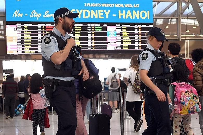 Police patrolling Sydney Airport last month. Experts have called for tighter security measures at Australian airports, including tougher screening of ground staff and identification checks for passengers.