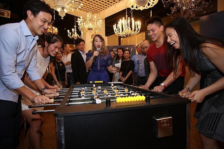 A team led by Teo Zhen Ren (left) takes on another led by Joseph Schooling (second right) at table football to raise funds for the Schooling Sports Academy.