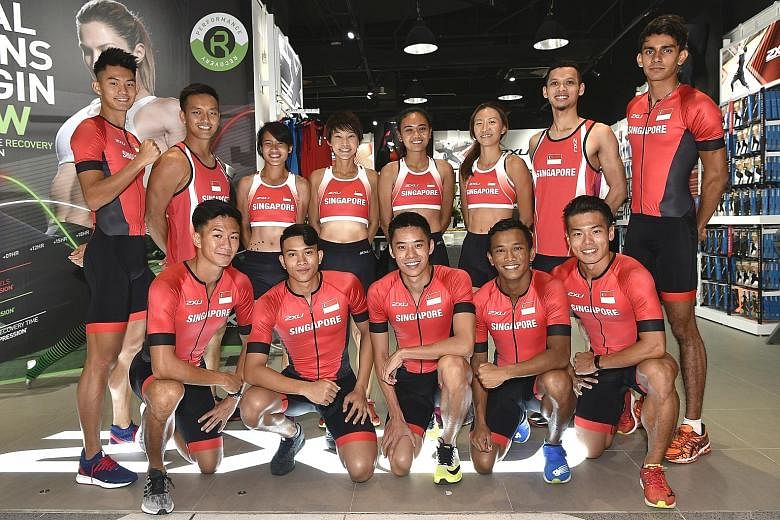 National athletics team members posing in their new sponsored competition attire, 2XU, at Suntec City yesterday.
