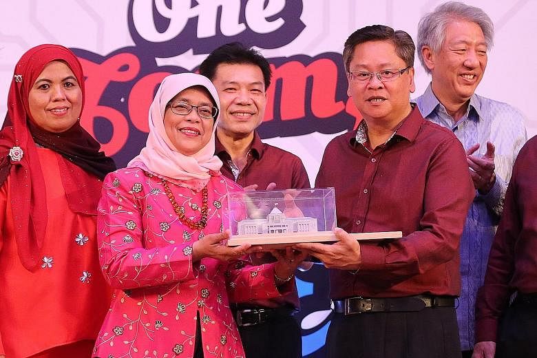 Speaker Halimah Yacob receiving a memento from Mr Tan Richard, general secretary of the United Workers of Electronics and Electrical Industries. With them are (from left) UWEEI executive council member Zahra Hadir, second assistant general secretary 