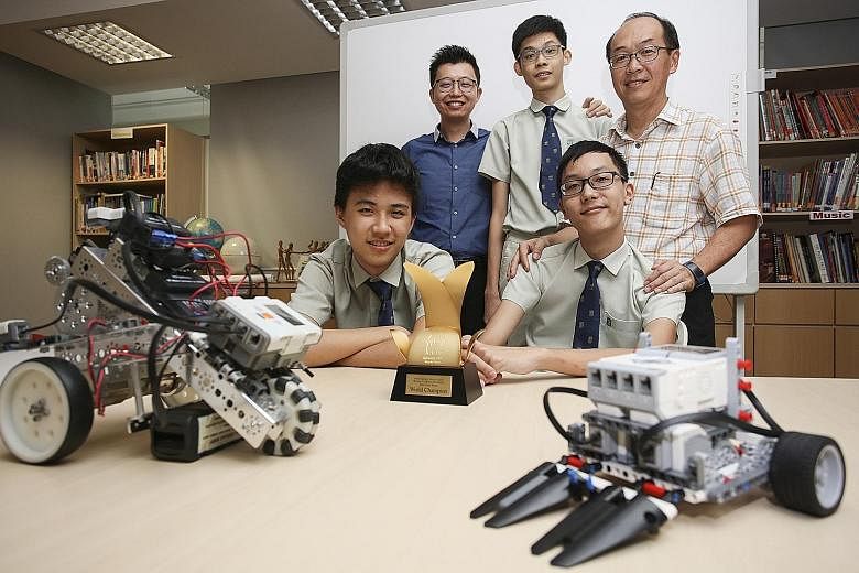 Students (from left) Shen Yixuan, Samuel Tan and Leong Heng Yew with their teachers, Mr Danny Choi (in blue) and Mr Terence Ten. The students won the Individual Team title in the RoboCup Junior League - CoSpace Rescue Secondary category last month.
