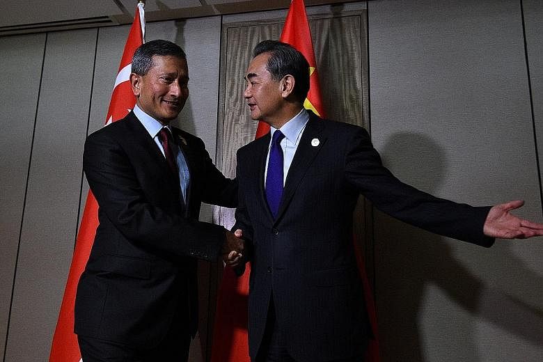 Chinese Foreign Minister Wang Yi greeting his Singapore counterpart Vivian Balakrishnan prior to their bilateral meeting on the sidelines of the 50th Asean regional security forum in Manila yesterday.