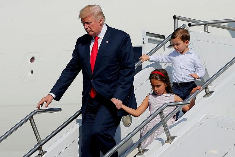President Donald Trump, with his grandchildren Arabella Kushner and Joseph Kushner, exiting Air Force One at Morristown Airport in Morristown, New Jersey, on Friday, for a summer "working vacation" at his Bedminster estate.