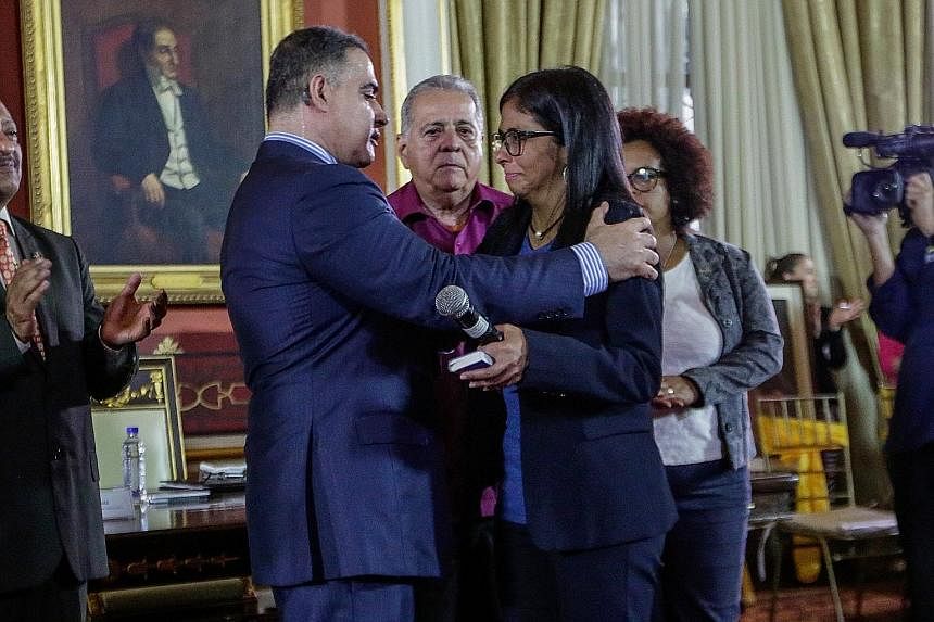 Left: Sacked chief prosecutor Luisa Ortega leaving on a motorbike after visiting the Public Prosecutor's office in Caracas, on Saturday. Below: Venezuela's new Attorney-General Tarek William Saab (left) hugging the Constituent Assembly president Delc