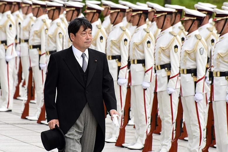 Japan's new Defence Minister Itsunori Onodera reviewing a guard of honour during a ceremony at the Defence Ministry in Tokyo on Friday. He has, since his first term as defence chief from December 2012 to September 2014, already been a vocal champion 