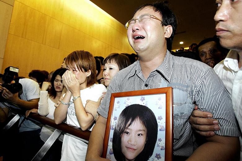 The parents of Huang Na, eight, who was killed in 2004, at the cremation at Mandai Crematorium. The story of her murder is one of the 25 that are published in Guilty As Charged. 