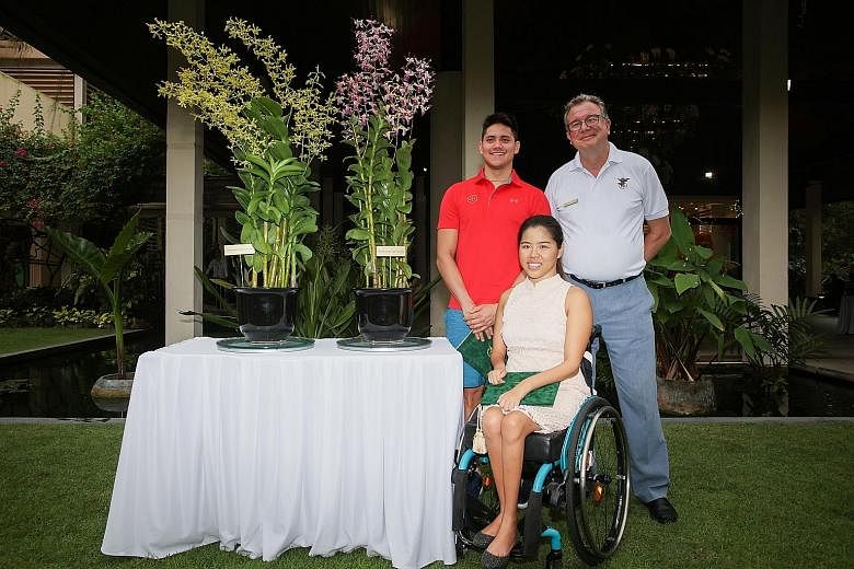 Joseph Schooling and Yip Pin Xiu with Dr Nigel Taylor, group director of the Singapore Botanic Gardens, alongside the orchid varieties that have been named after the two swimmers.