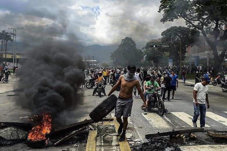 Anti-government activists building a barricade in Venezuela's third city, Valencia, on Sunday, a day after the new Constituent Assembly - loyal to President Nicolas Maduro - started functioning in the country. The controversial assembly has quickly u