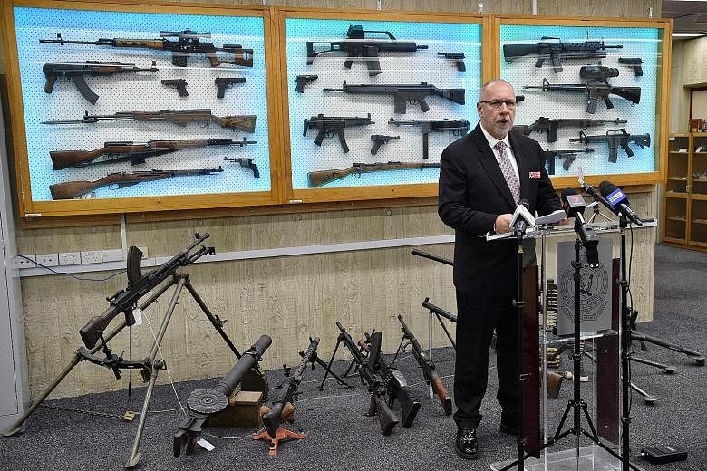 Detective Chief Inspector Wayne Hoffman of the New South Wales Police speaking to reporters yesterday with guns seized from criminals displayed behind him.