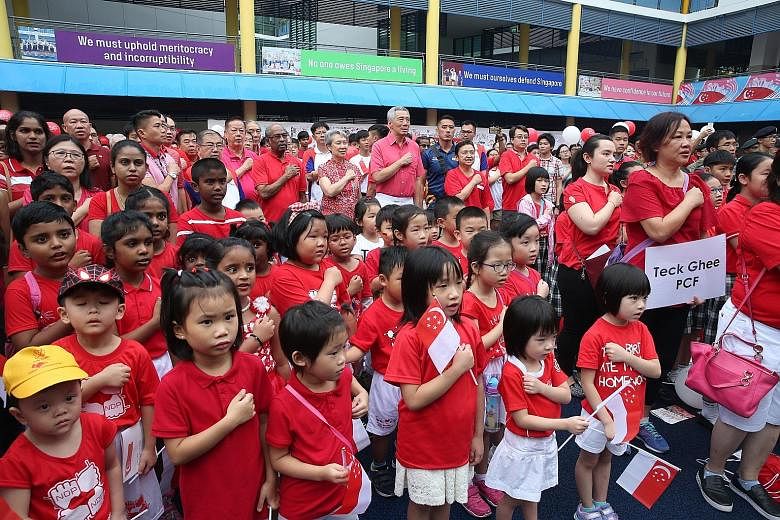 Prime Minister Lee Hsien Loong and Mrs Lee reciting the Pledge with residents, grassroots leaders and children at the Teck Ghee National Day Observance Ceremony yesterday.
