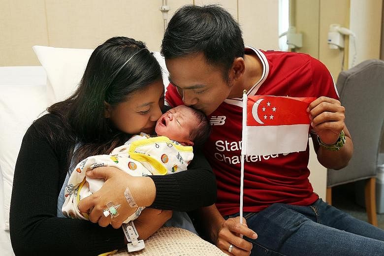 Above: Ms Soh Bei En with her newborn son Matheus Tan Pin Xu at Mount Alvernia Hospital yesterday. The baby boy is the first child of Ms Soh and her husband Tan Shi Chang, and was six days overdue. Left: Madam Rabitah Razali, Mr Eddy Kurniawan and th