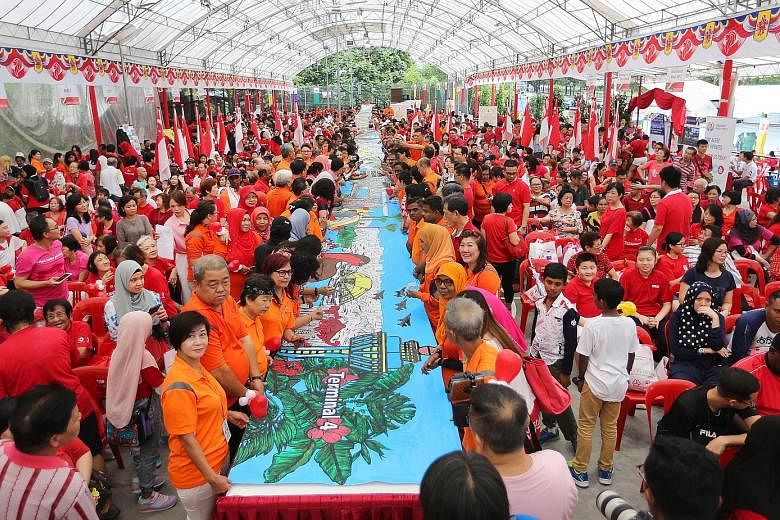 Marsiling residents yesterday unveiled a record-setting, 52m-long banner painting that charts Singapore's development from independence in 1965 till today.