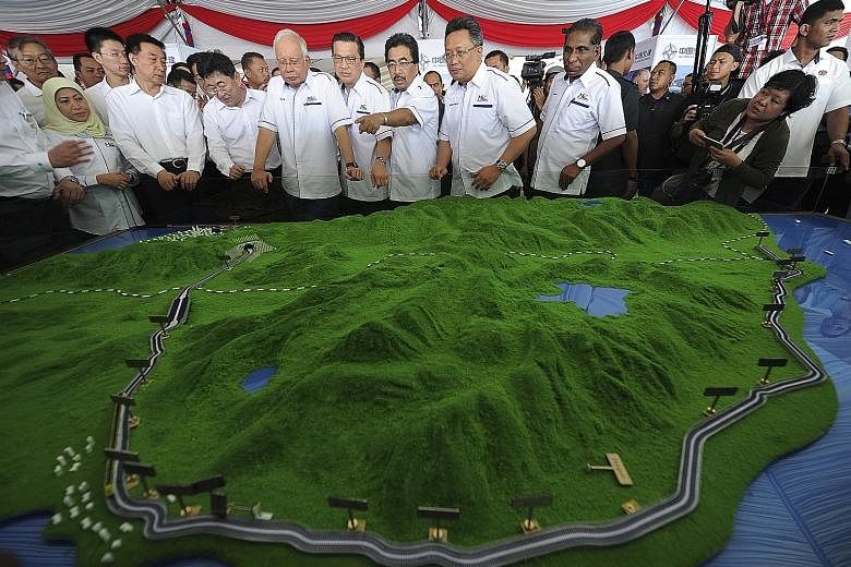 Malaysian Prime Minister Najib Razak and China's State Councillor Wang Yong (front row, third from left) viewing a model of the East Coast Rail Link in Kuantan yesterday. Mr Najib described the rail link as a "high-impact project that will seamlessly