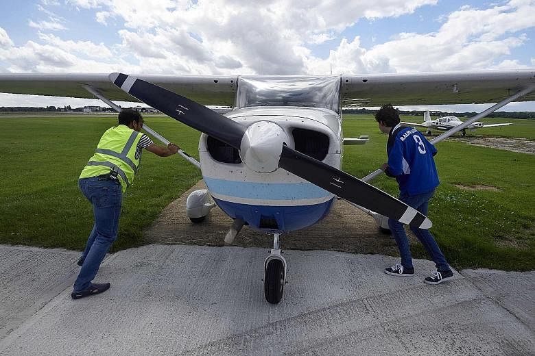 Passenger Adam Nicholas helping pilot Somasekhara Pemmiredy (left) to park the Cessna 172 plane after a Wingly flight over London, at the London North Weald airfield on Aug 1.