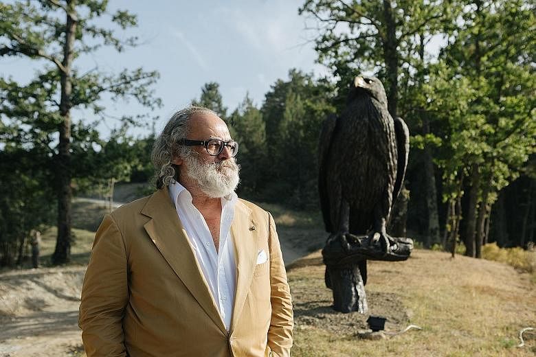 An alligator-skin bag (above) in the clutches of an eagle statue is on display at the Stefano Ricci boutique in New York. The brand's founder Stefano Ricci (left, at his home in Firenzuola, Italy) considers the bird a symbol of strength and control.
