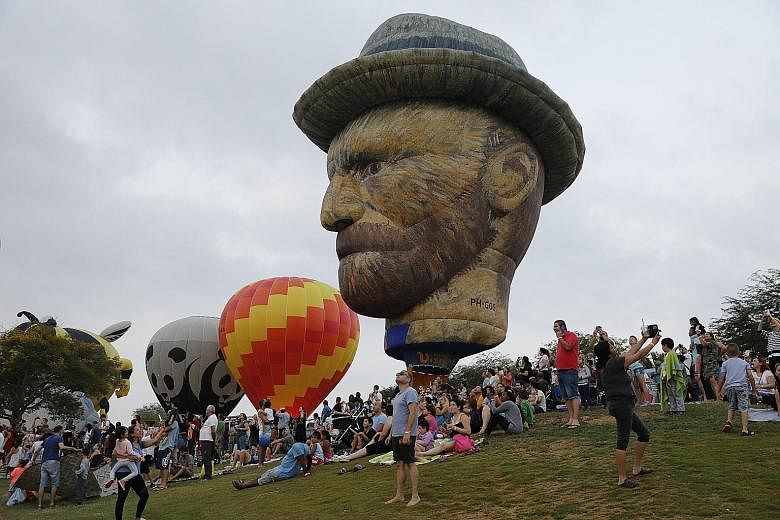 A hot-air balloon in the likeness of artist Vincent van Gogh hovering above spectators and participants at the International Hot Air Balloon Festival at Eshkol National Park in Northern Negev, Israel, yesterday. Israeli and international teams took p